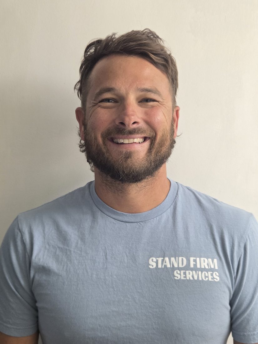 Cody, founder of Stand Firm Services, wearing a branded shirt